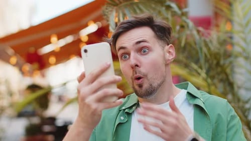 Man Reacts with Shock to Phone News