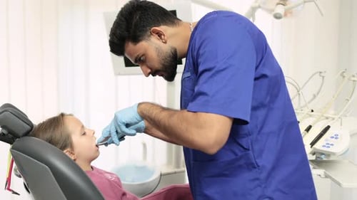 Dentist Examining Young Child's Teeth in Clinic
