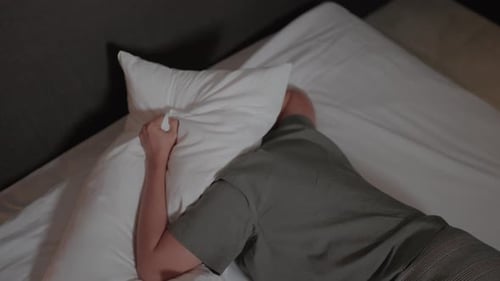 Adult Lying Prone on Bed Face Down in Pillow