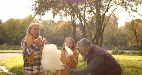 Happy Family Eating a Cotton Candy at Autumn Park