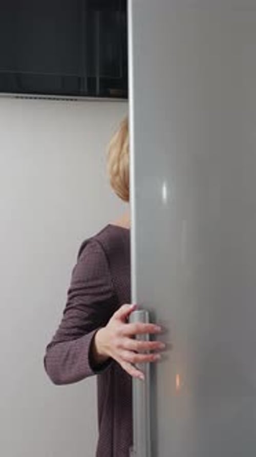 Woman Opening Refrigerator in Home Kitchen