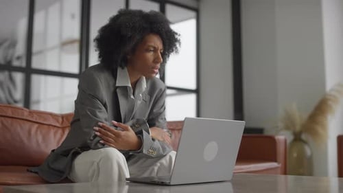 Stressed Businesswoman Looking at Laptop in Office