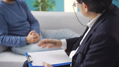 Psychologist asking questions to his patient with psychological problems for diagnosis in the office