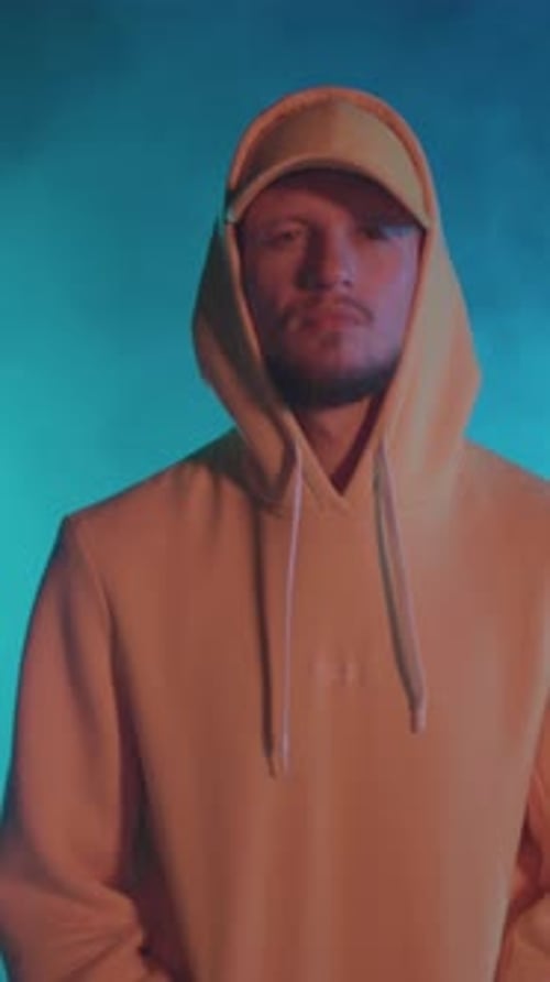 Gesichtsporträt einer attraktiven talentierten HipHop-Bboy-Tänzerin in gelbem Kapuzenoutfit, die vor der Kamera posiert