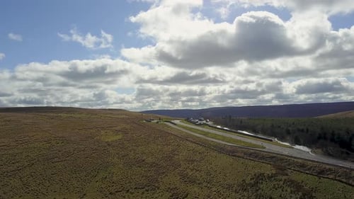 Aerial view of winding road through green hills, United Kingdom.