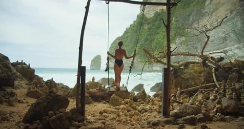 Woman on Swing By Towering Cliffs and Sea Adult Girl Relaxing on Tropical Beach Near Ocean Waves
