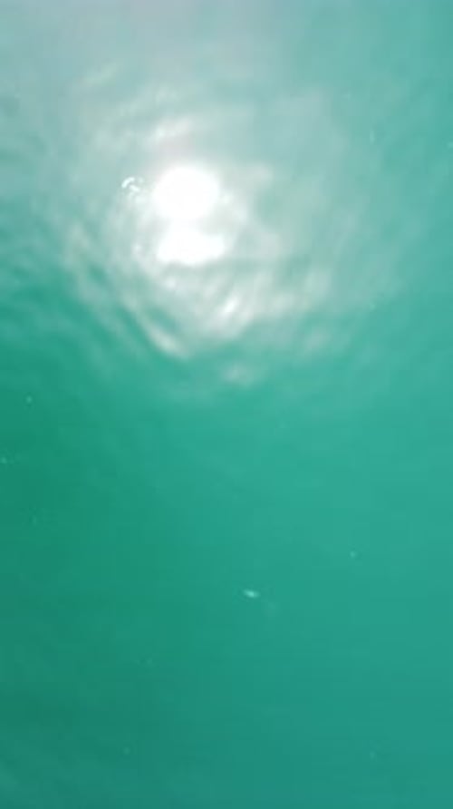 Vertical Aerial View on Sea Water Surface Camera Flies Over Clear Sea Water Sun Glare Abstract