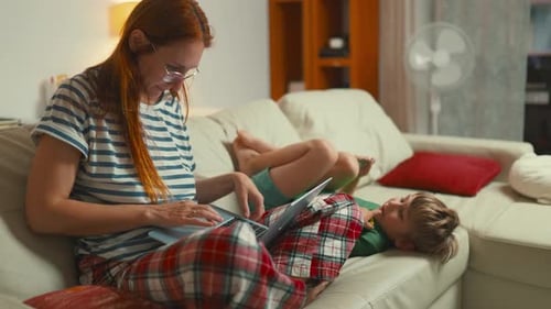 Familienzeit zu Hause mit Kindern, während Mama weiterarbeitet