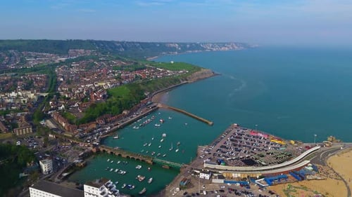 Seagulls soar above Folkestone pier. Seaside coastal aerial view over harbour