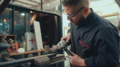 Joven haciendo metalistería con amoladora angular