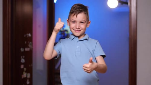 Excited Boy Gives Double Thumbs Up in Hallway
