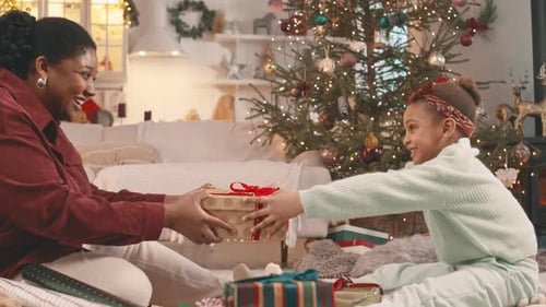 Smiling Woman and Child Exchanging Christmas Gift