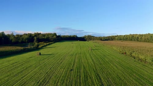 Aerial shot flying over an agricultural field at sunset