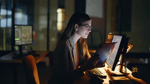 Woman Analyzing Data Late at Night in Office