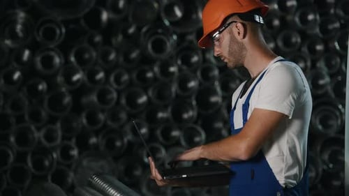 Man in uniform works on the production. Industrial modern technology