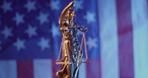 Lady Justice Statue with American Flag Backdrop