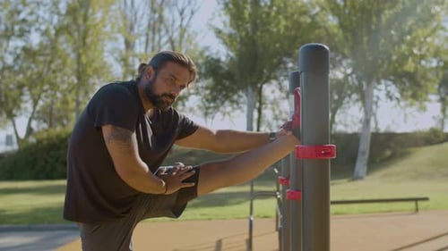 Male Athlete Doing Stretching Exercises in Park in the Morning
