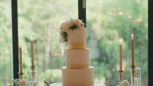 Wedding Cake Topped with White Roses and Candles