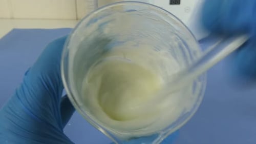 cliché d'une émulsion cosmétique en cours de préparation en laboratoire. Vidéo montrant les gants de l'opérateur