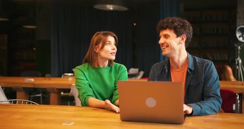 Colleagues Collaborating on Laptop in Modern Office Coworking Space Together Working