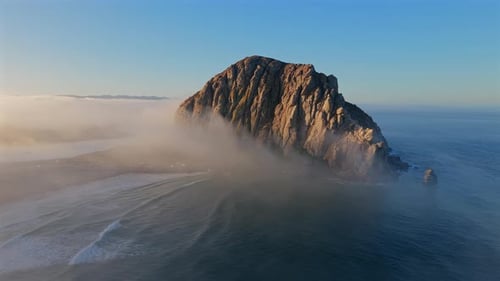 Majestic Coastal Rock Formation at Dawn Surrounded By Misty Waves Ideal for Adventure