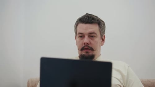 Man Using Laptop Indoors At Home During Daytime