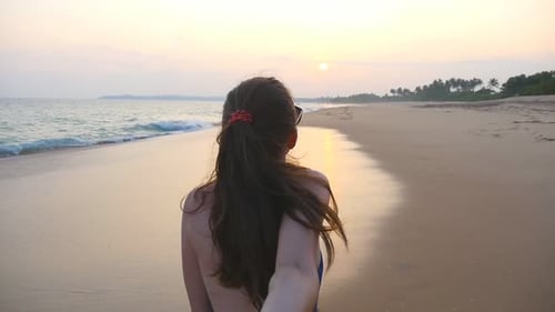 Follow Me Shot of Beautiful Girl Holds Male Hand Walking Near Sea Shore Young Woman in Swimsuit