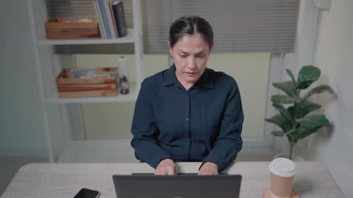 Woman Working at Laptop in Bright Home Office