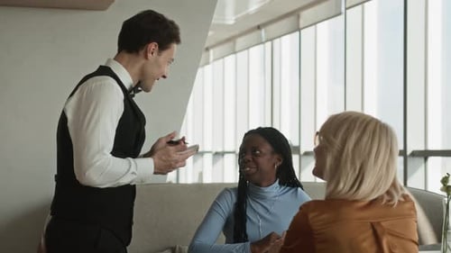 Waiter Taking Order from Female Guests in Fancy Restaurant
