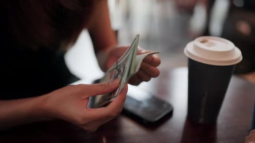 Close-up of female hands expertly counting money to pay interest to loan employees,