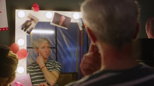 Performer Applies Makeup in Dressing Room Mirror