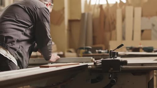 Woodworker Cutting Wooden Planks in Workshop