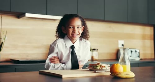 Smiling Child With Sandwich and Fruit in Kitchen