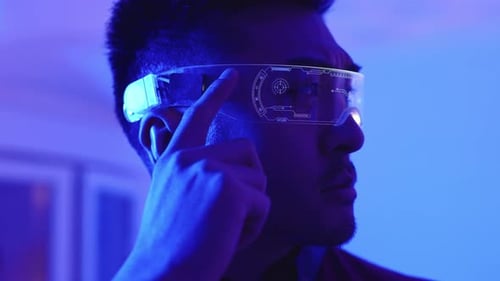 Man Wearing Futuristic Augmented Reality Glasses in Blue Light