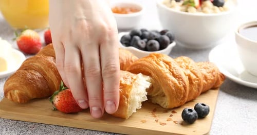 Crisp croissant on wooden board for breakfast, food