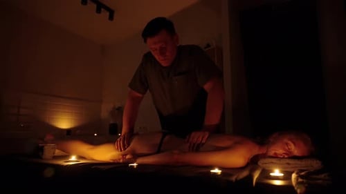 Hand of Masseuse Doing Massage Back with Aromatherapy Oil on Back of a Woman Customer in Spa Salon