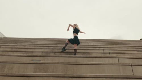 Young Woman Dances on Concrete Steps
