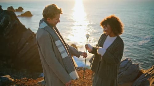 Lovely Pair Dating Sunset Sea Cliffs Closeup Enamoured Man Bringing Flower