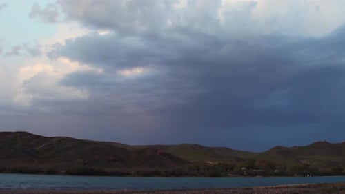 Zeitraffer eines Sommersturms mit dunklen Regenwolken, die den Himmel umhüllen. Beobachten Sie, wie es über das F fährt
