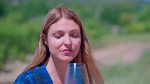 Junge Blondine probiert Wein in einem Weingut