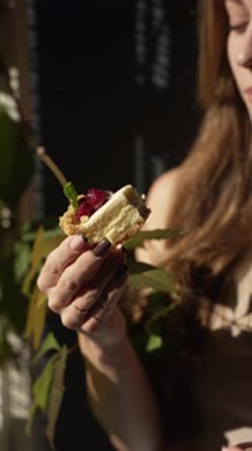 Young Woman Eats Tart Outdoors in Sunlight