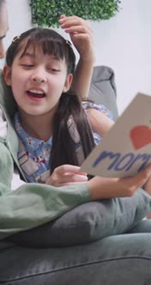 Loving Child Shows Mom Handmade Card for Birthday