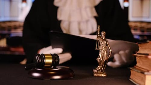 Nahaufnahme von Gavel Law, Büchern und der Justizstatue, die Autorität und Urteilsvermögen in der Moderne symbolisieren