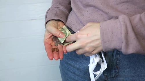 Hands Pulling Money from Denim Pocket