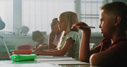 Elementary School Students Raising Hands to Provide Correct Answer During Geography Lesson