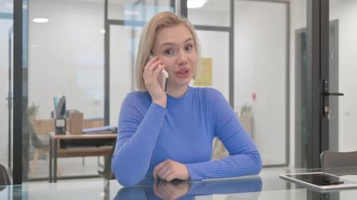 Young Woman Talking on Cellphone in Office