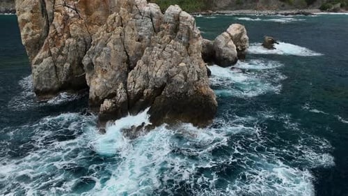 Dramatic Color of the Sea Waves Crashing Against the Rocks Aerial View on a Wild Beach