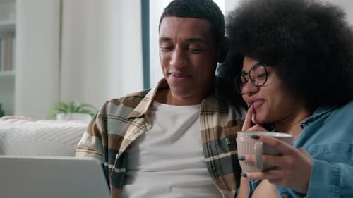 Smiling Couple Looking at Laptop at Home