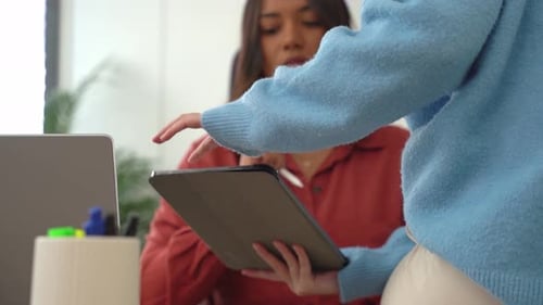 Businesswomen Collaborating on Digital Tablet in Office