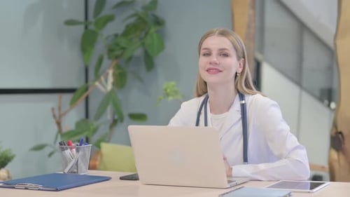 Smiling Young Doctor Working at Her Desk